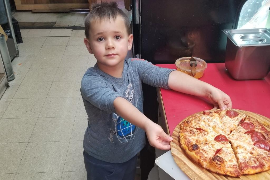 Young guest with Brooklyn's Pizza at Grimm's Deli